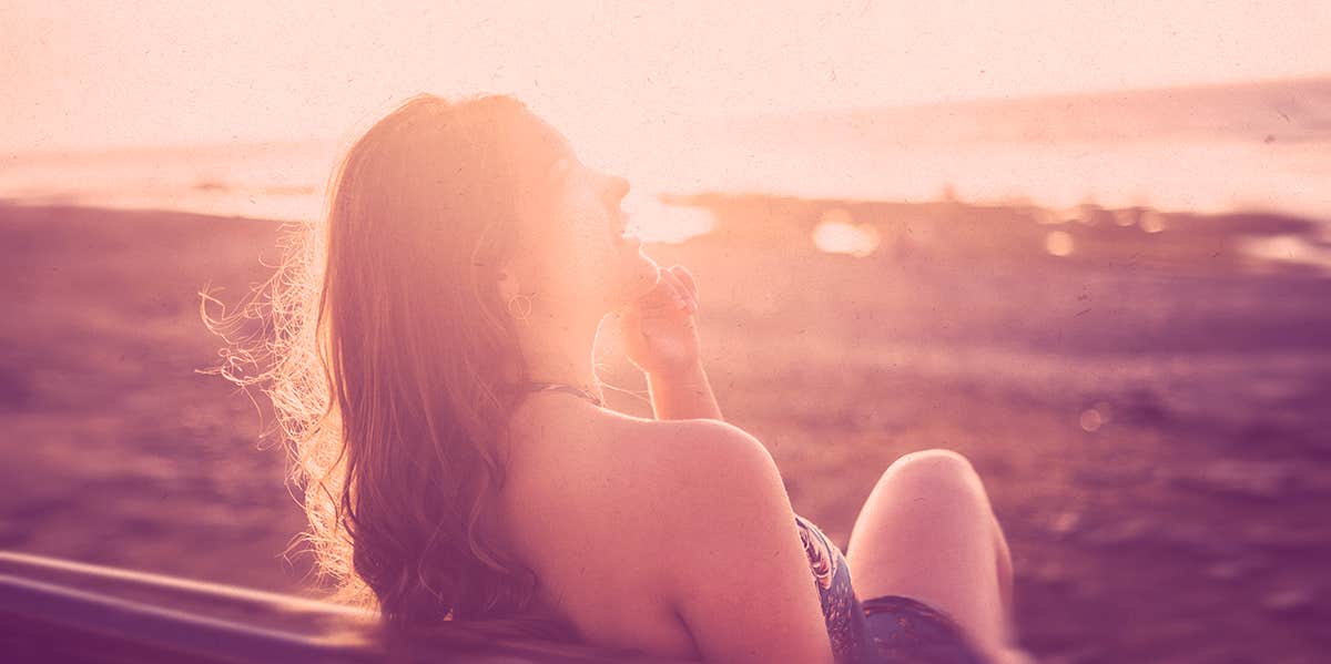 woman sitting at the beach, sunset