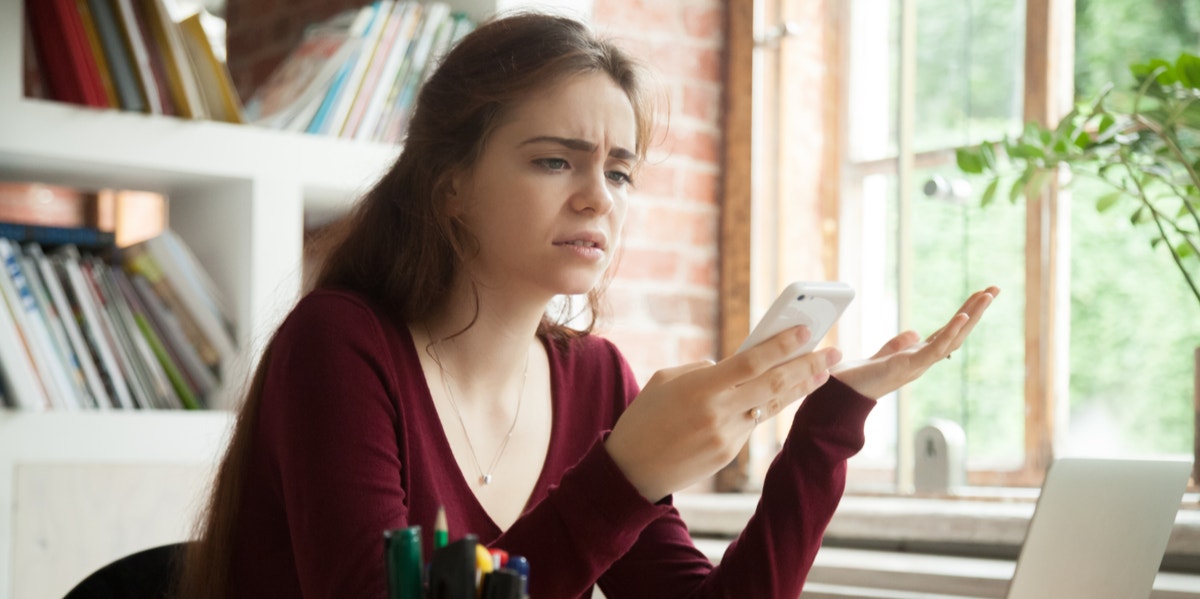 confused woman looking at phone