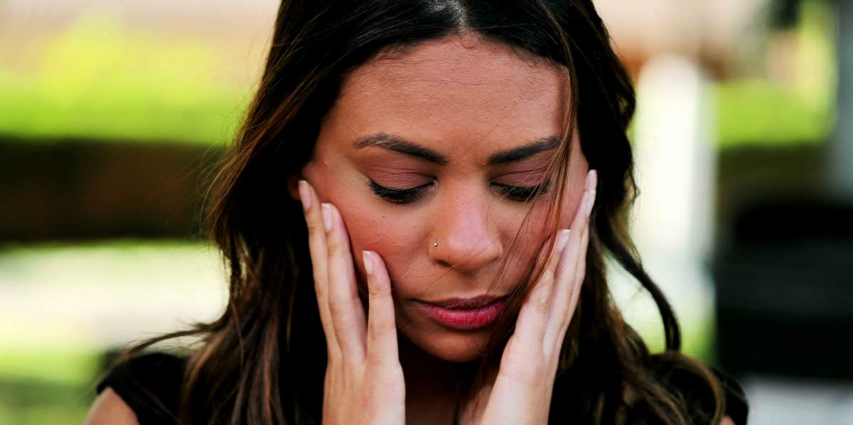 grieving woman with hands on her face