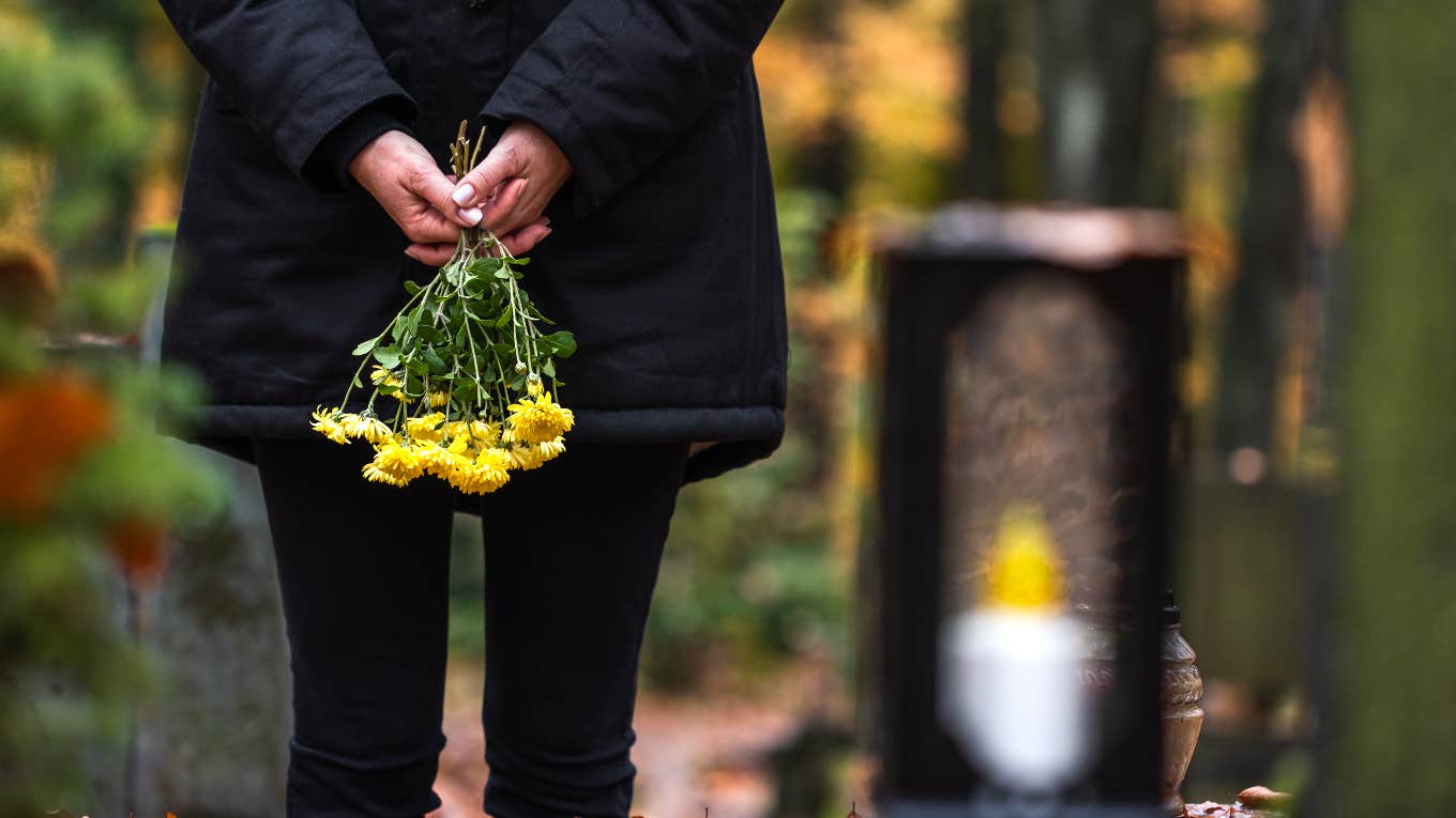 person holding wilting yellow flowers