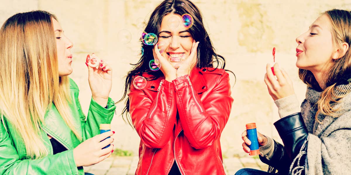 three women friends blowing bubbles