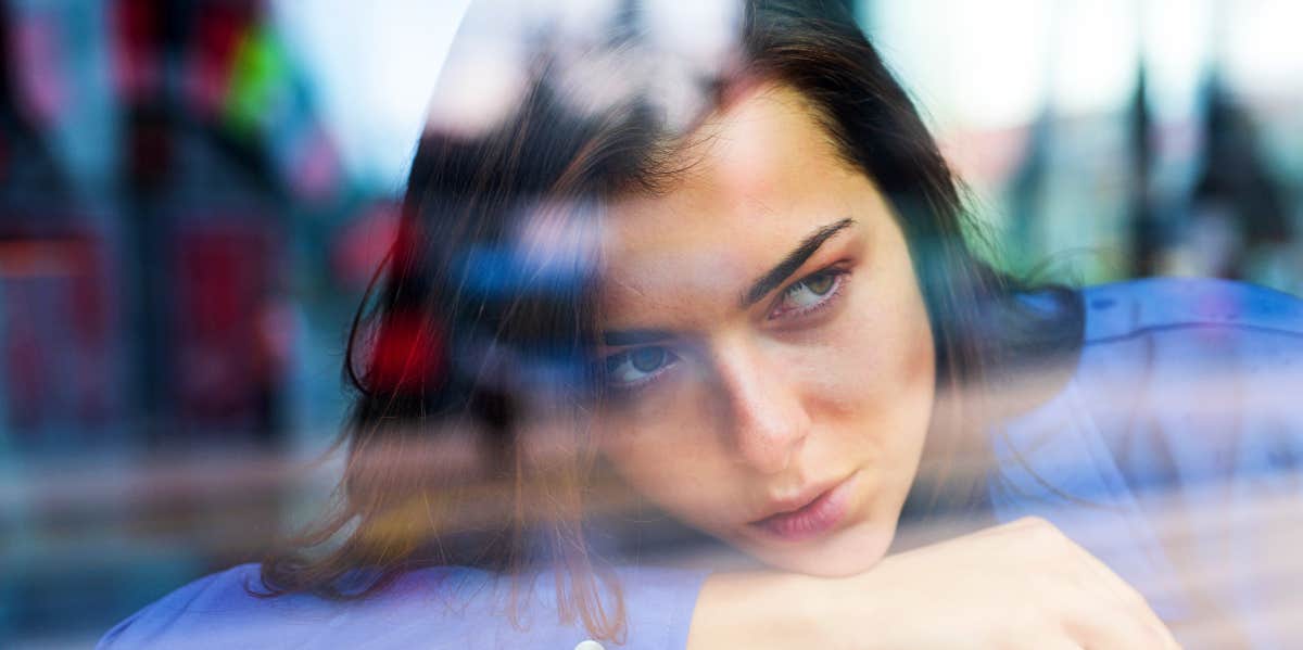 Woman looking through glass window