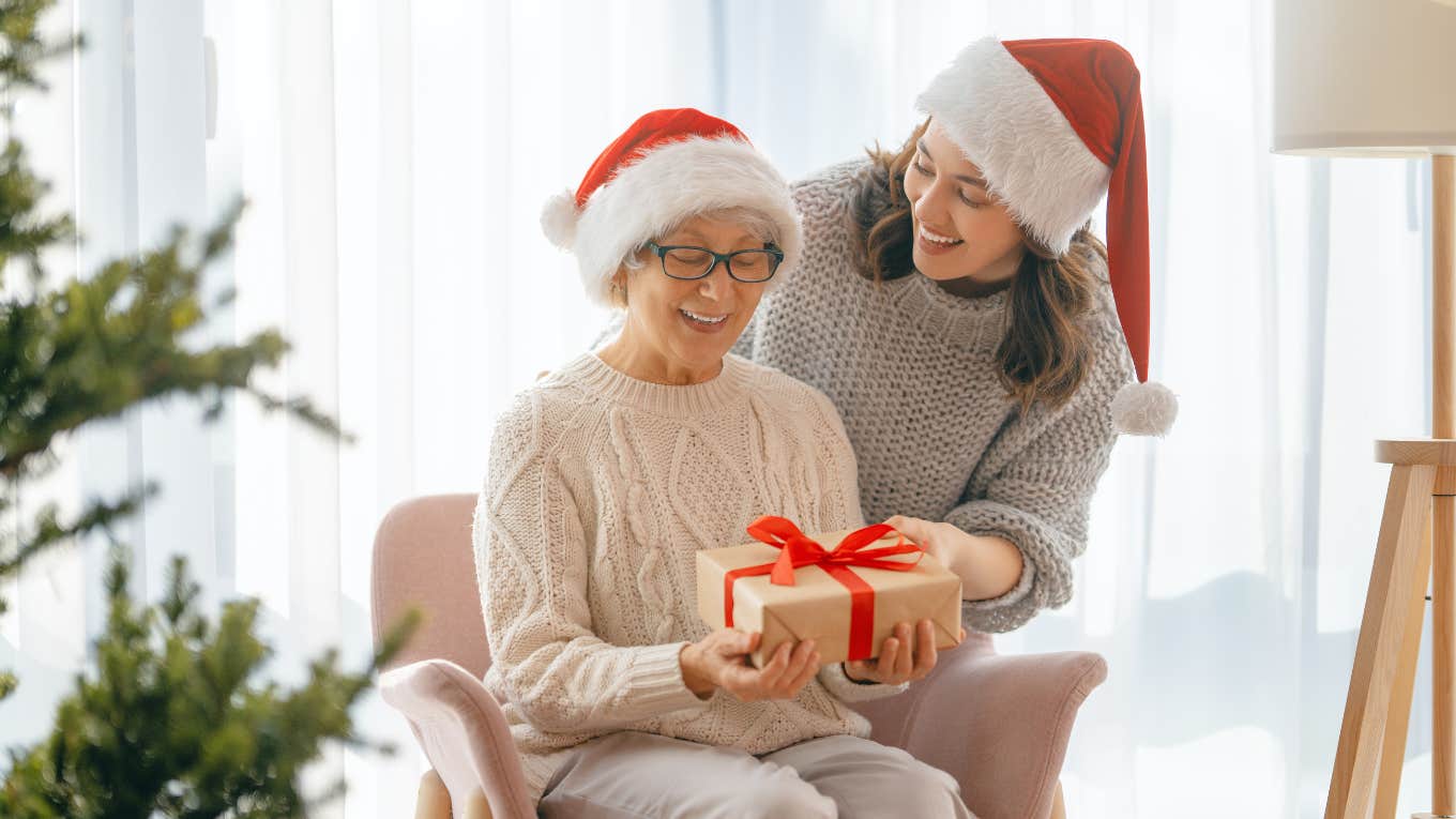  mom and her adult daughter exchanging christmas gifts.