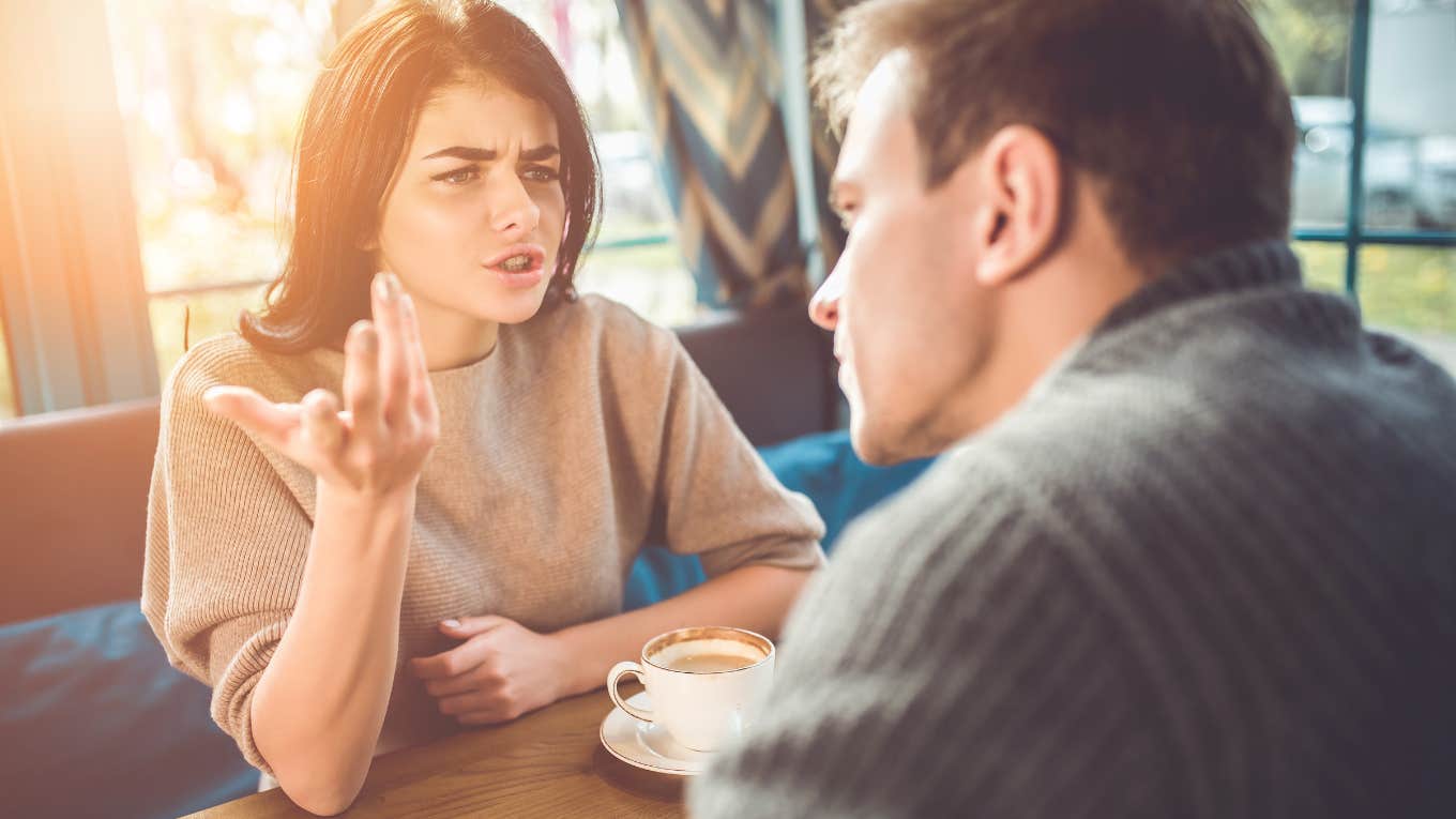 man and woman arguing while sitting at a table in a restaurant