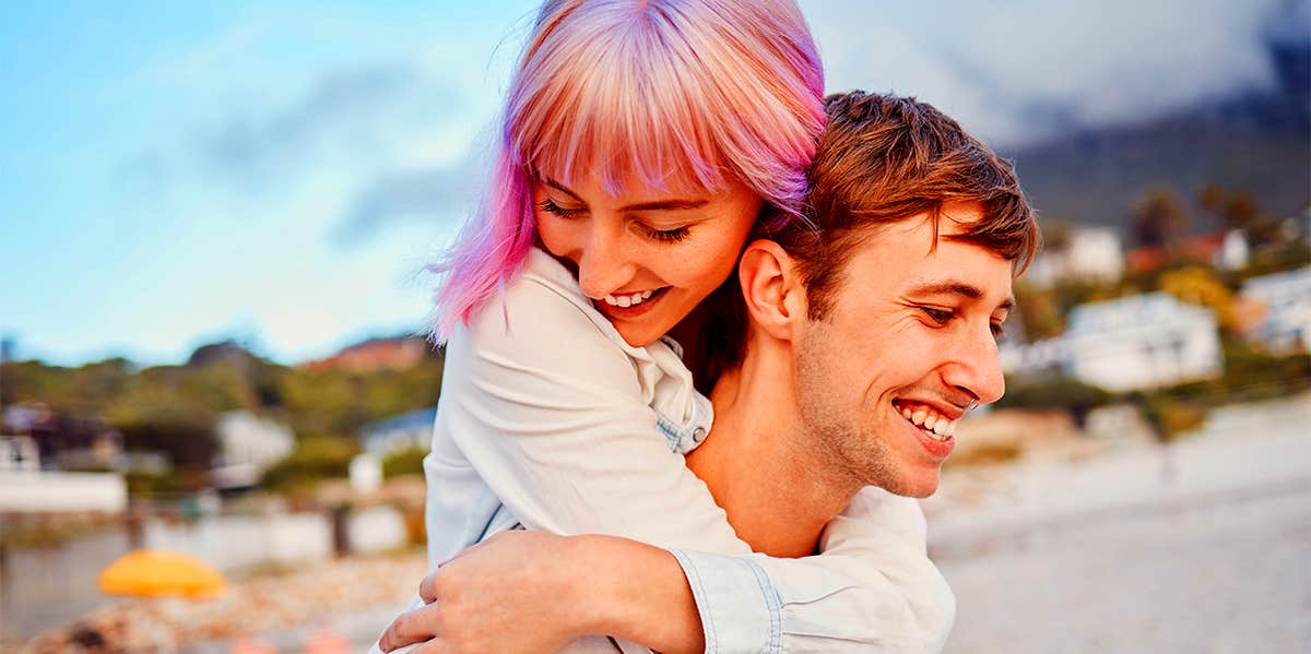 man carrying girlfriend on his back 