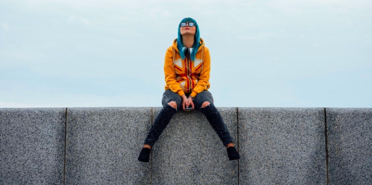 woman on ledge with phone