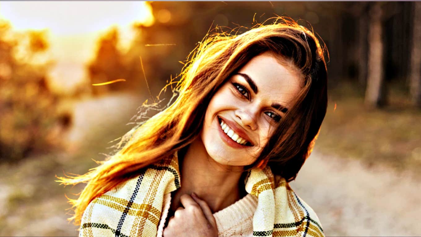 Glowing happy young woman on country road 