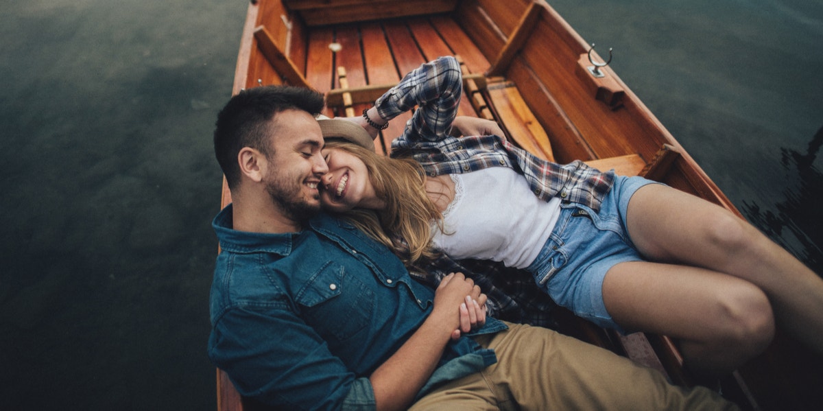 Why Happy Couples Don't Blast Relationship Updates On Facebook couple cuddling in boat