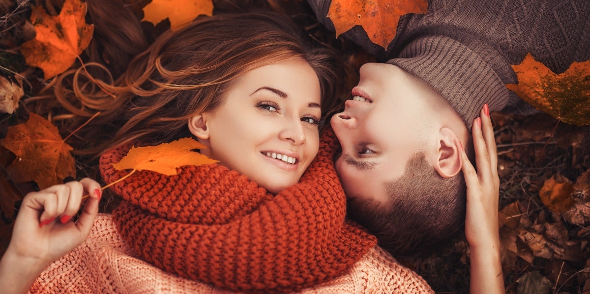 man and woman lying on top of Fall leaves