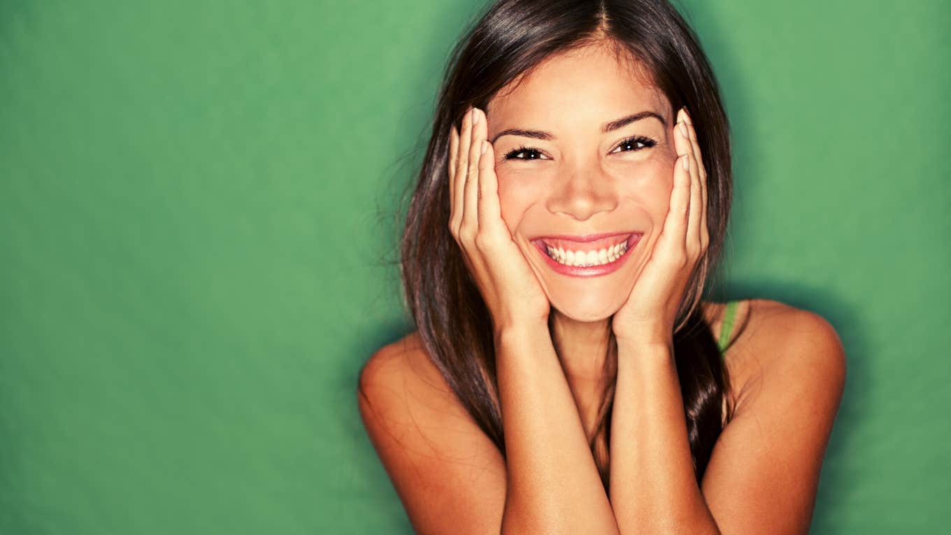 Surprised excited woman on green background