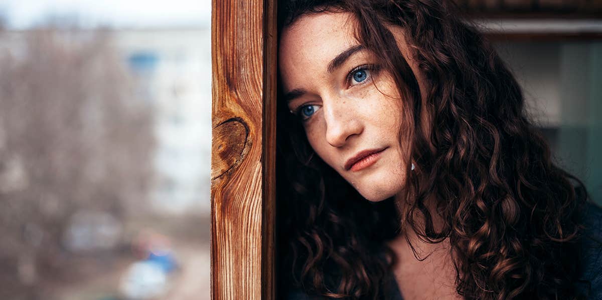 Woman sadly looking out window