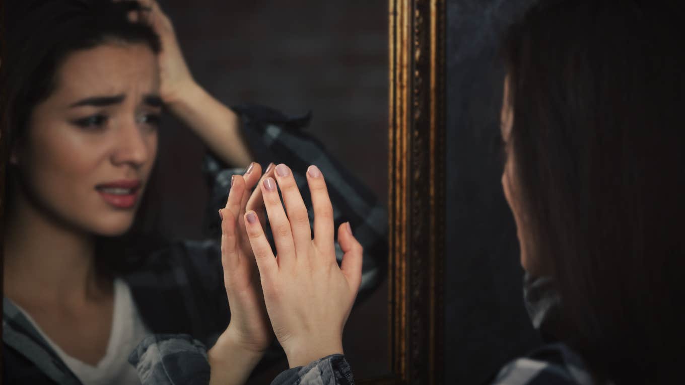 Woman looking at her self in the mirror 