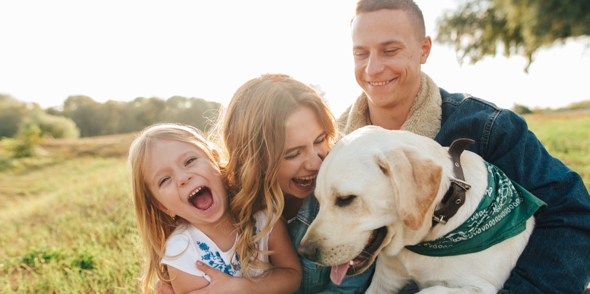 woman cuddling with dog and family