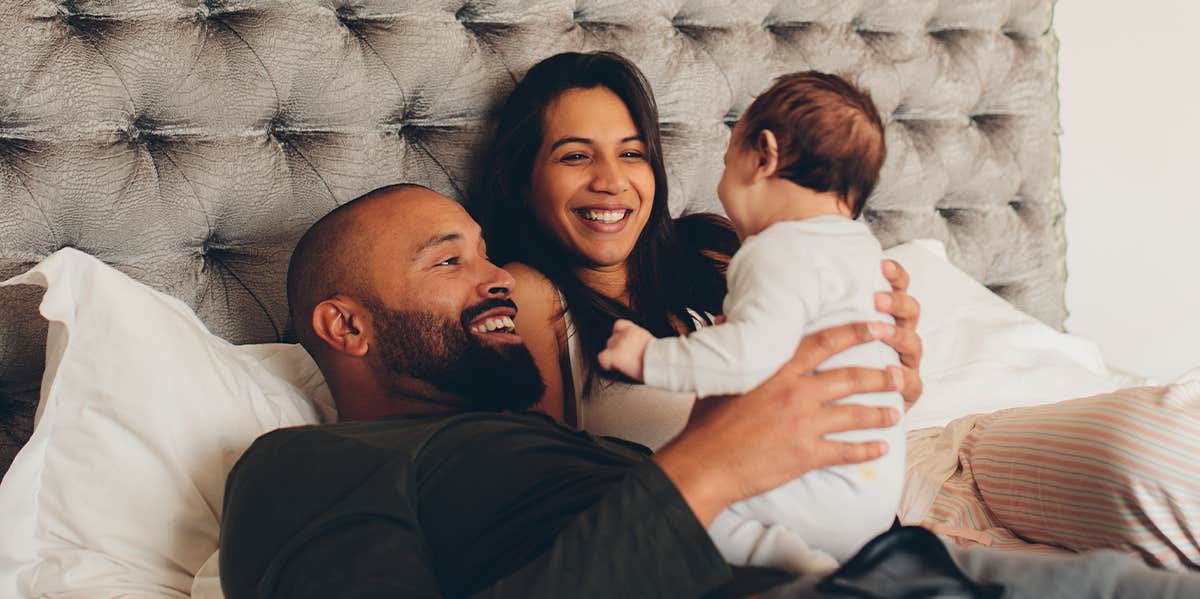What Really Happens To Marriage After Having Kids, According To Research new parents holding their baby