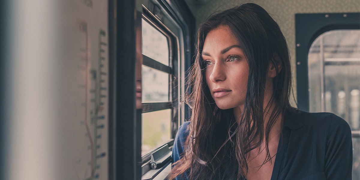 upset woman looking out a window