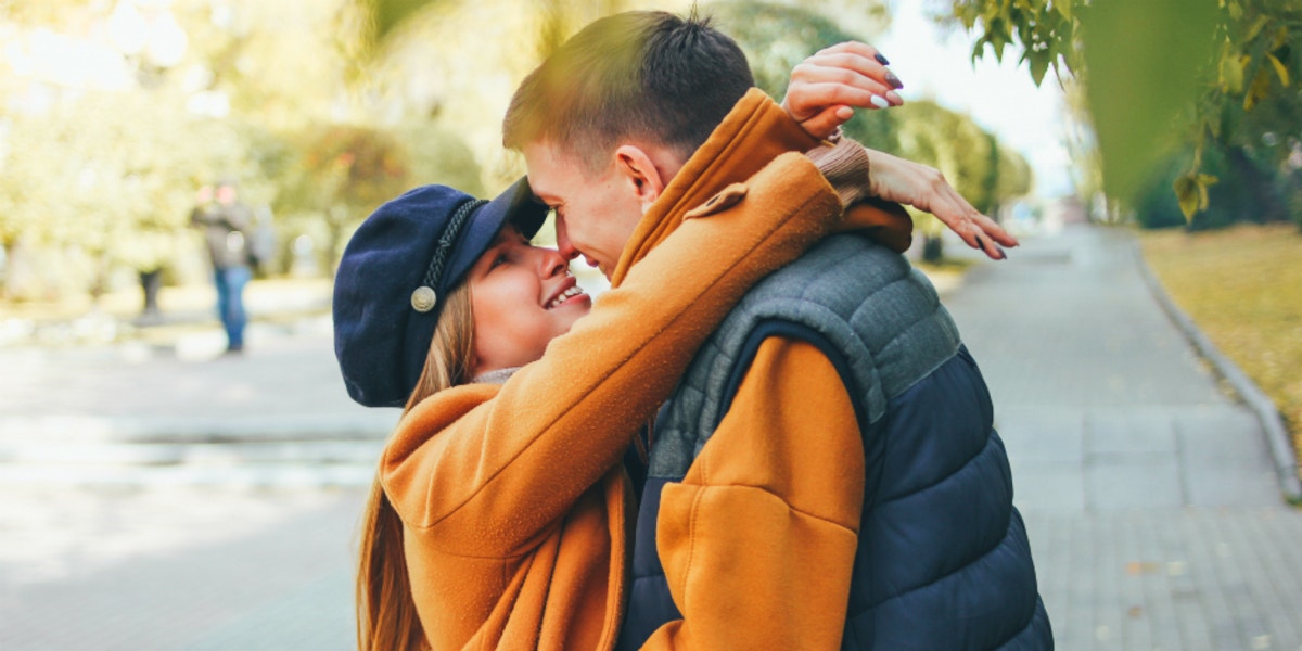 Signs He's Insecure About Being In A Relationship With You man and woman kissing on street.
