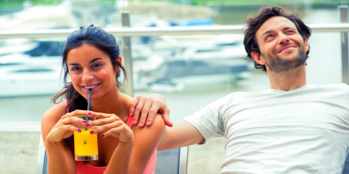 woman sipping drink next to boyfriend wondering if he still loves his ex