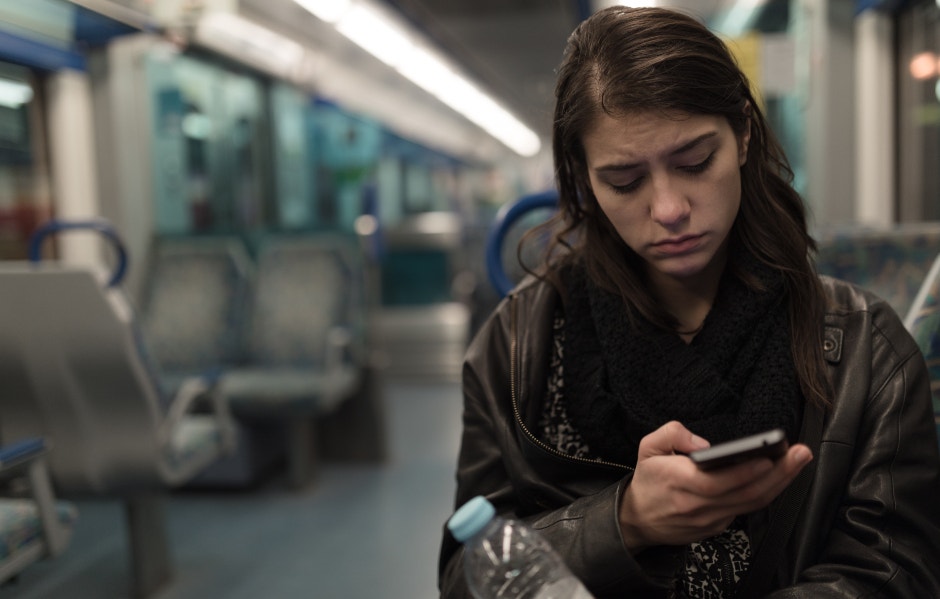 unhappy woman looking at memes on phone