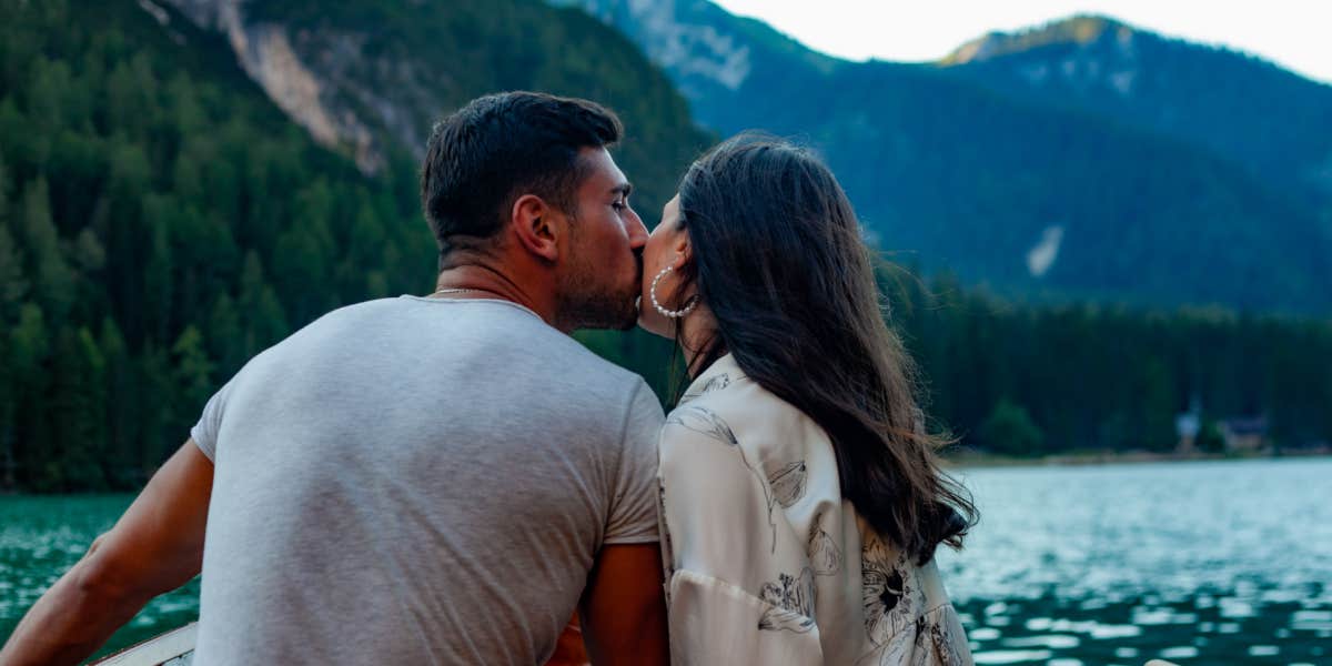 couple on a lake, man kissing woman's cheek