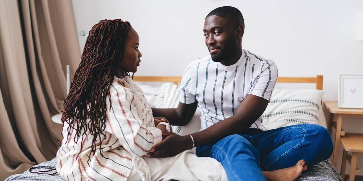 couple sitting on bed talking