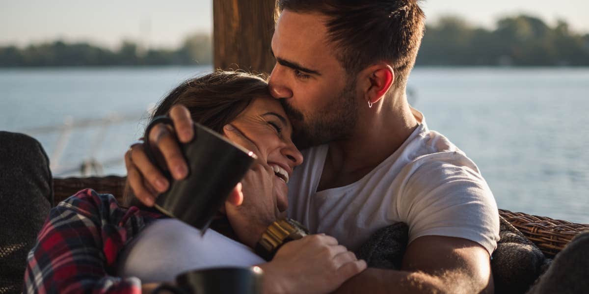 couple cuddling by lake 