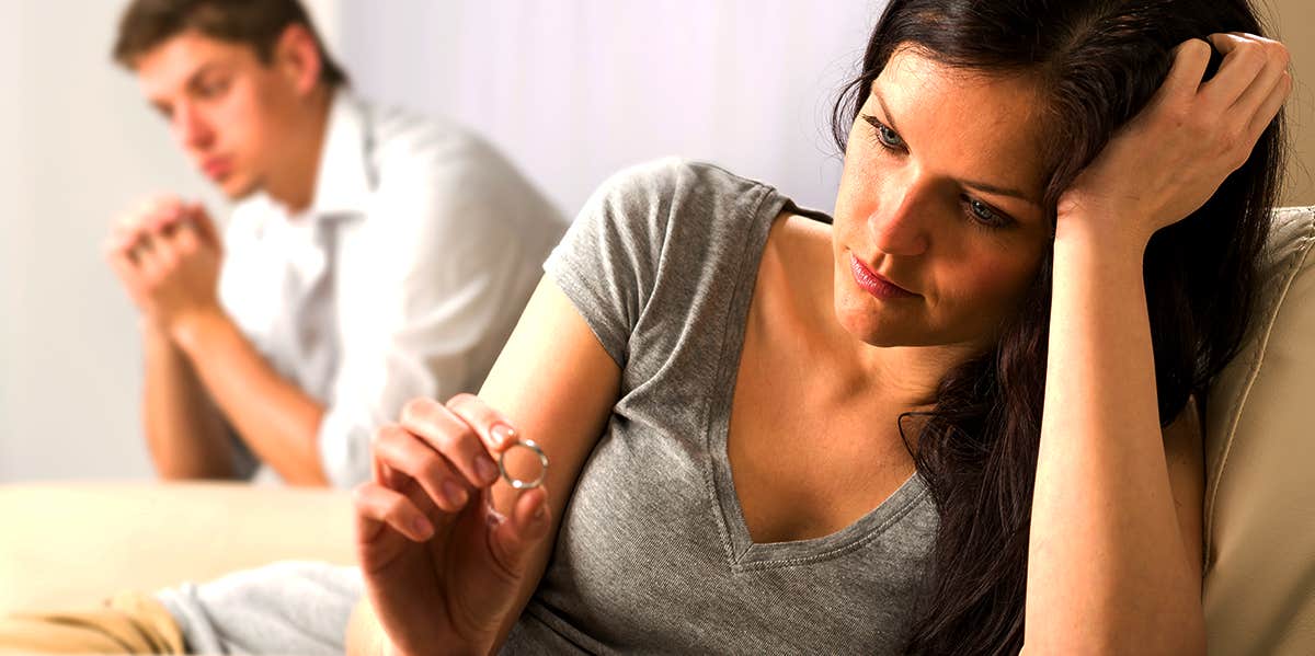 woman sadly looking at wedding ring