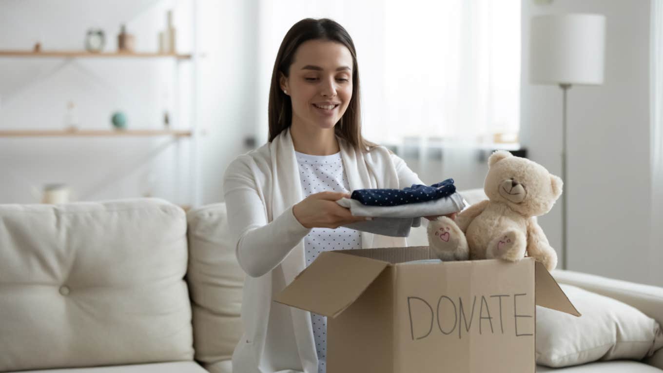 woman packs box with clothes and toys to donate to kids
