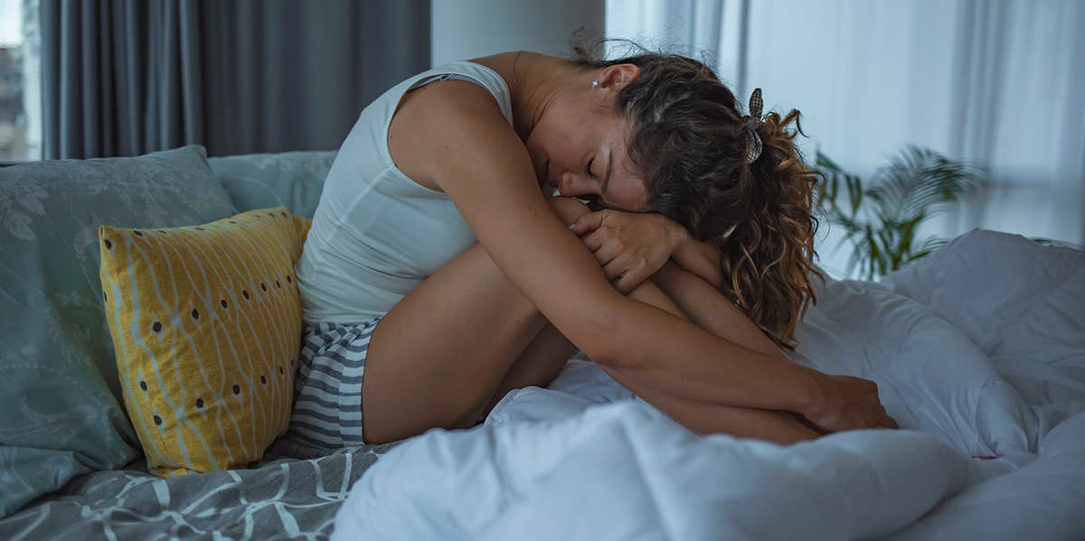 woman sobbing on bed