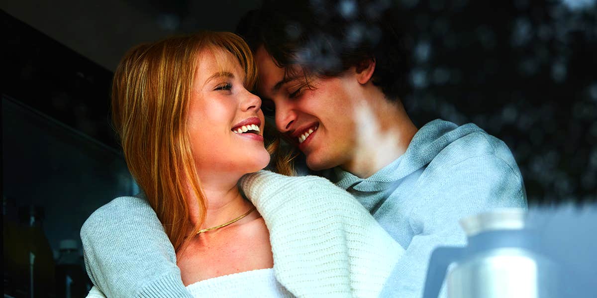 Here's How To Get The Chemistry Back In Your Relationship couple cuddling and laughing