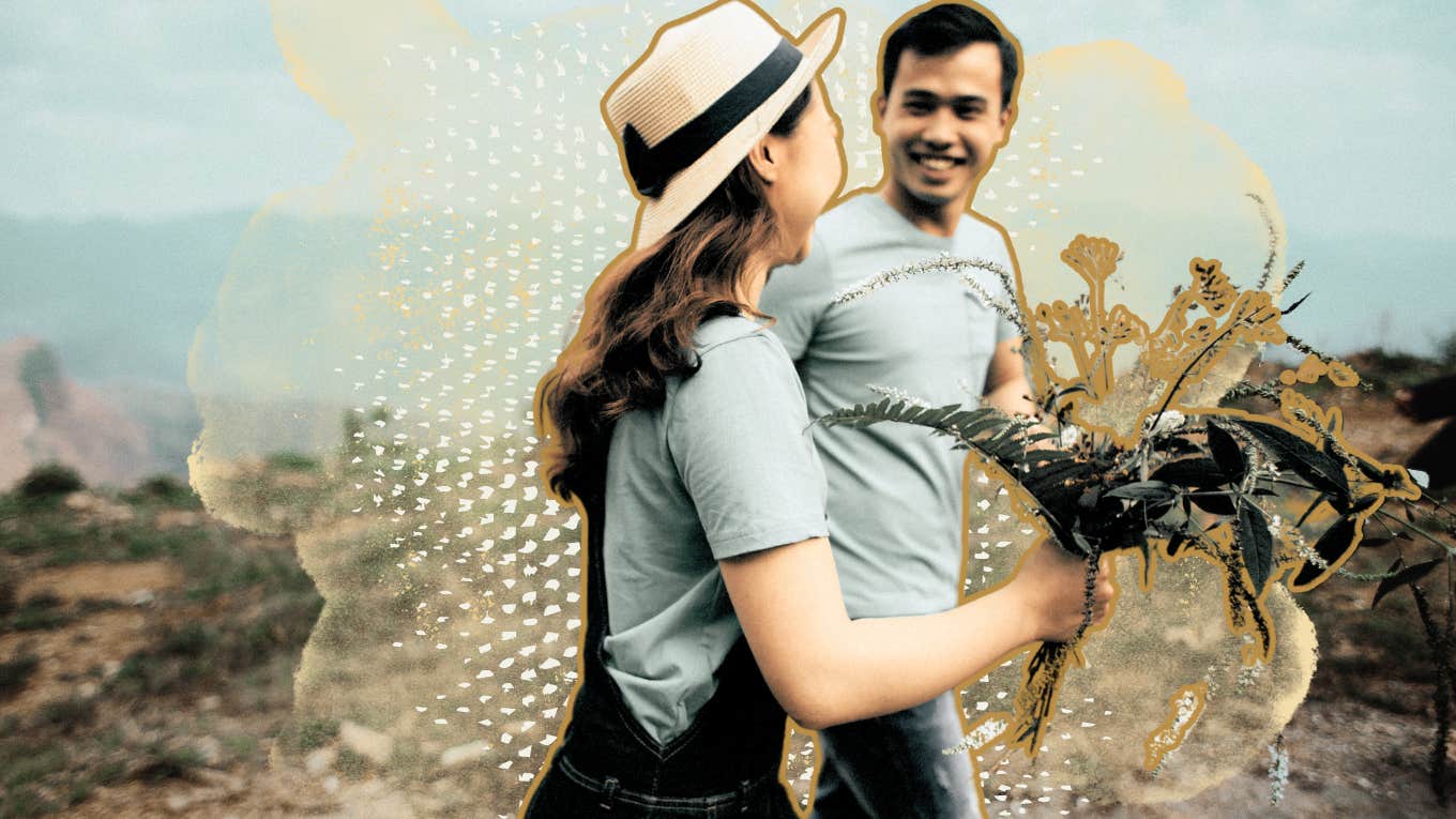 Man picking wild flowers while on walk and handing them to partner