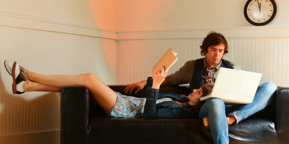 man and women reading together on the couch