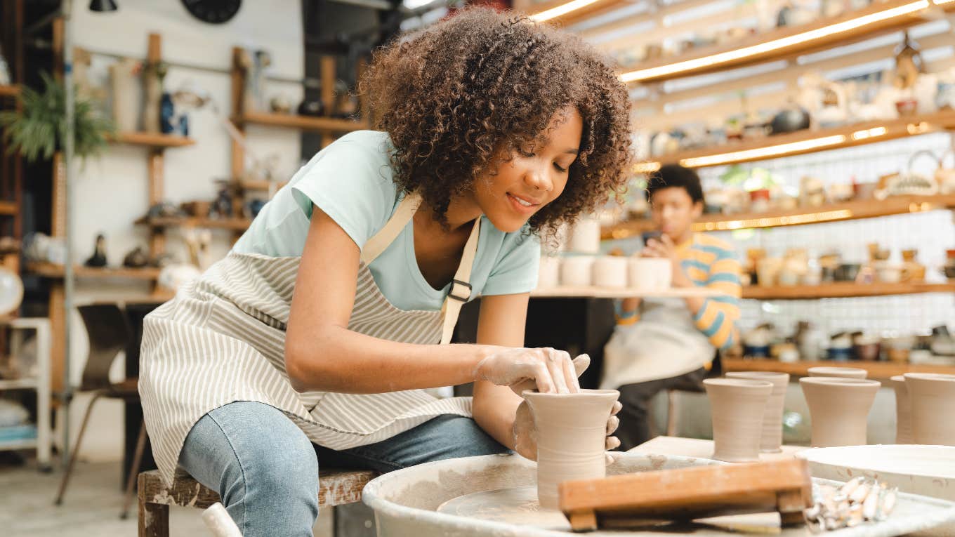 happy woman doing pottery as a hobby