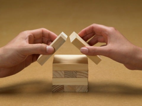 couples hands building blocks house