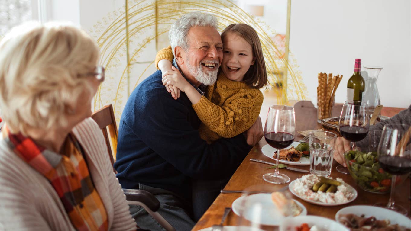 a grandpa hugs a child while grandma looks on at dinner table