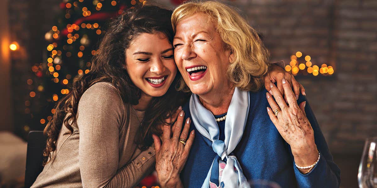 grandmother and granddaughter hug at the Christmas table