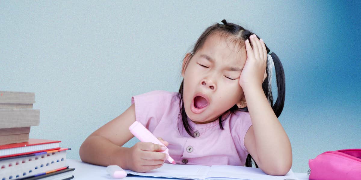 little girl yawning at desk