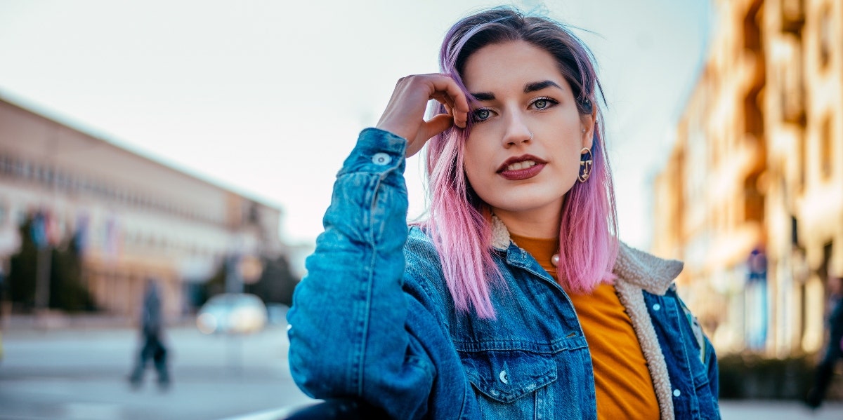 honor your unique self woman with pink hair posing