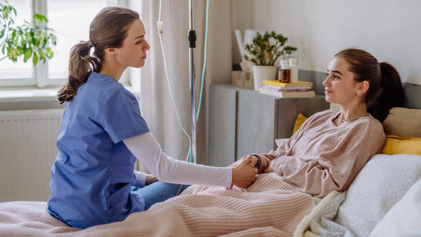 nurse tending to patient in hospital bed