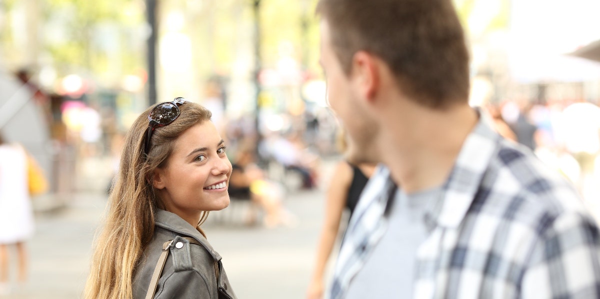 man looking back at smiling girl