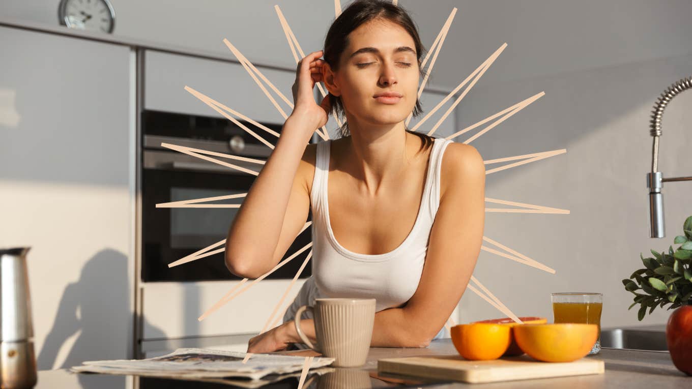 Woman with the morning sun light on her face as she sits in the kitchen