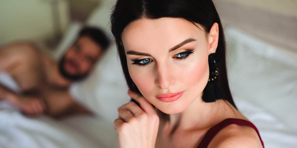 woman thinking in bed with cheating boyfriend next to her