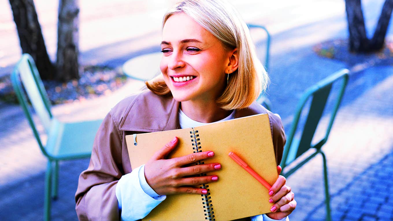 girl sitting at table outside with notebook