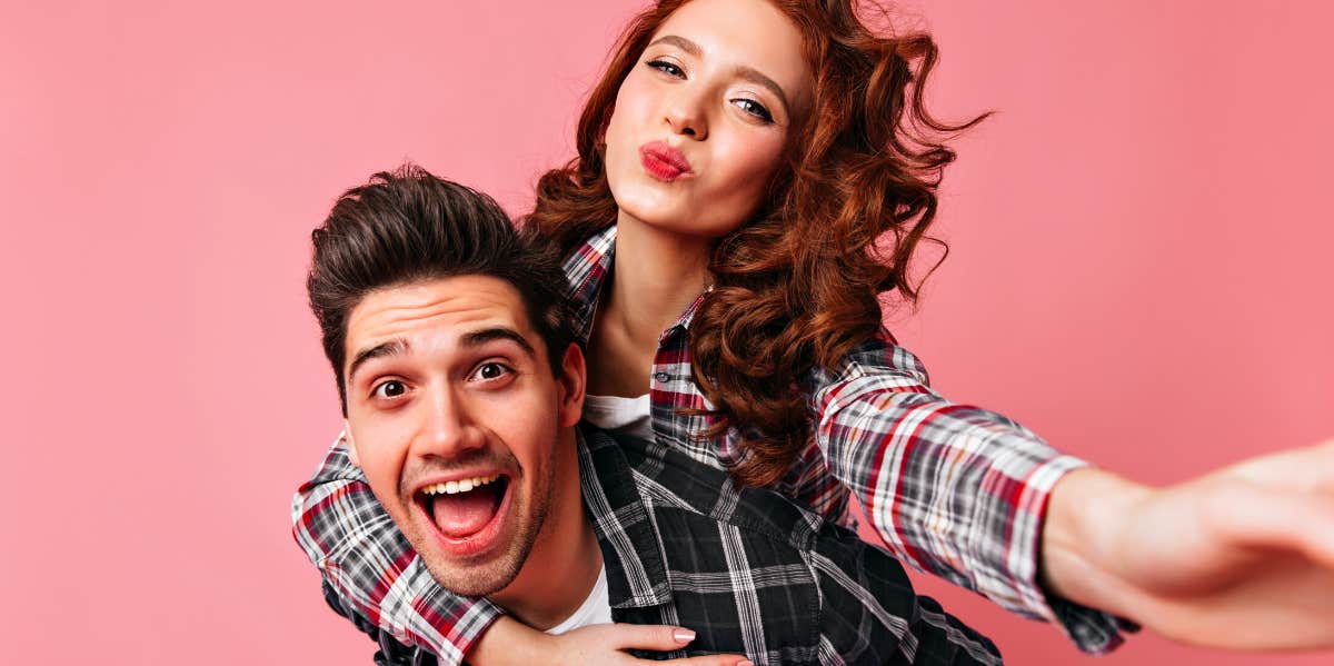 happy couple in front of a pink background