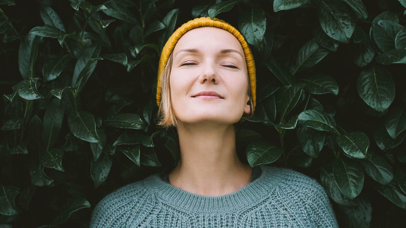 woman posing in front of greenery 