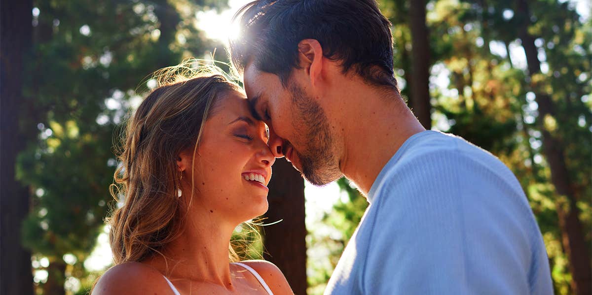 man and woman embracing in forest