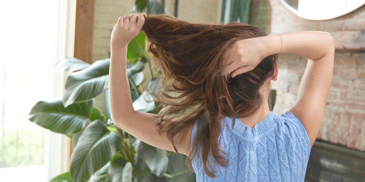 woman pulling long hair behind head