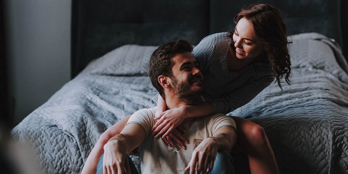 man and woman smiling in bedroom