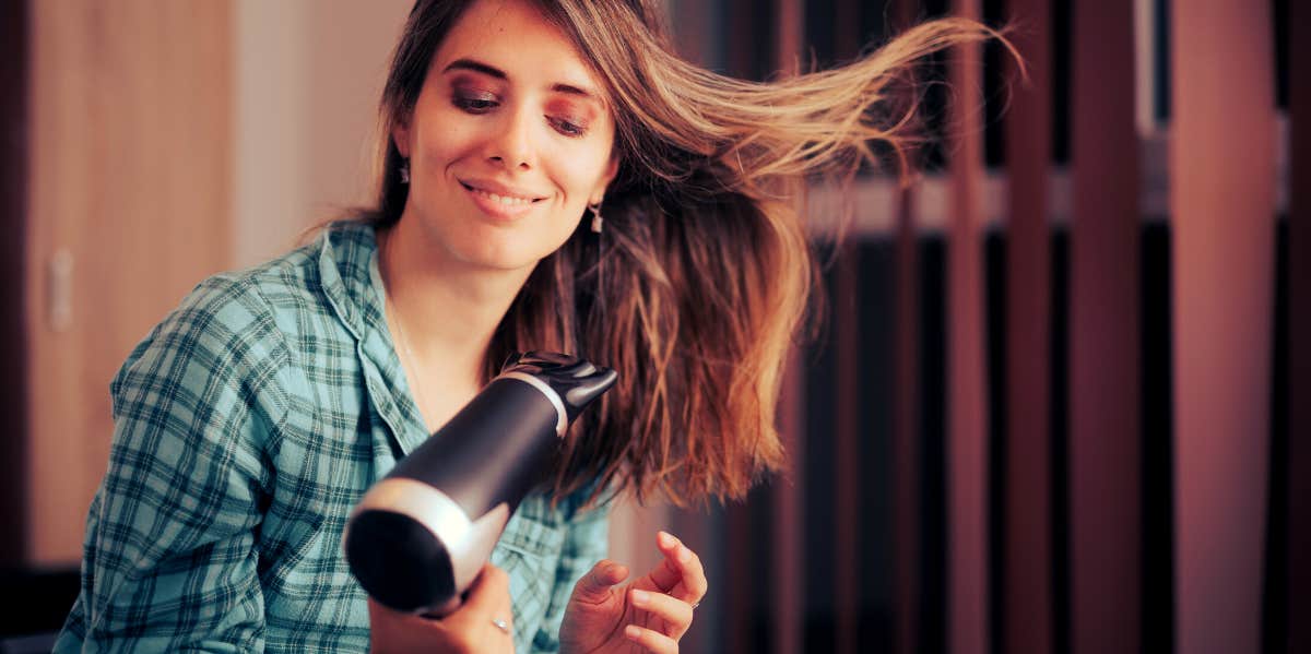 How To Give Yourself A Blowout In 11 Steps woman doing a blowout