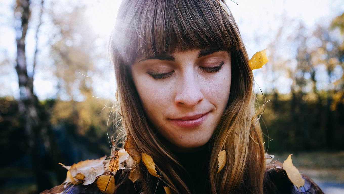 beautiful woman dressed boho style sitting on the autumn leafes