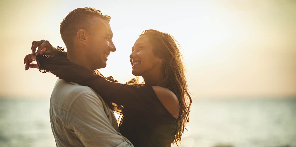 happy couple hugging at beach